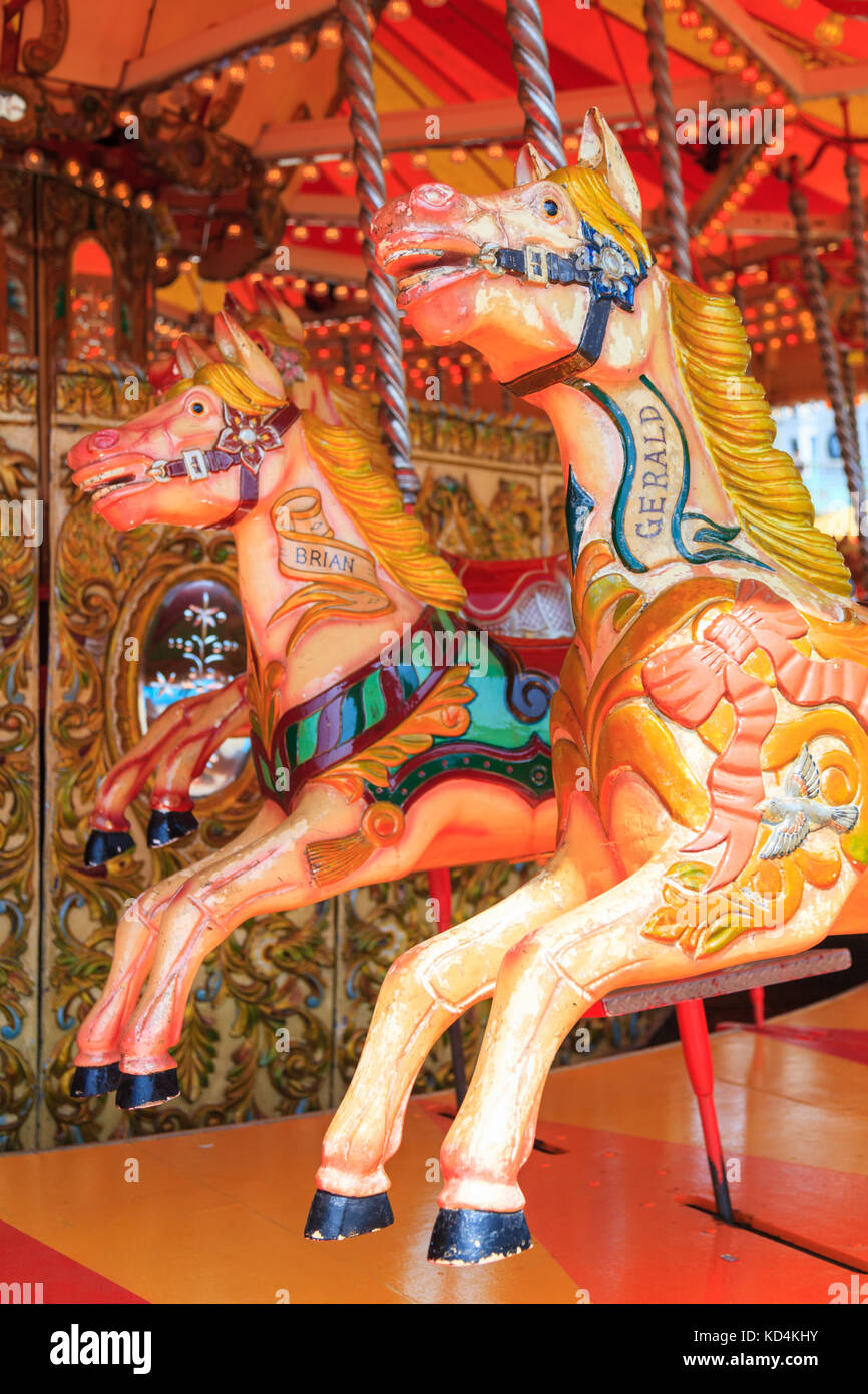 Bemalte antike Holzpferde auf einem traditionellen viktorianischen Karussell am britischen Meer auf dem Messegelände Brighton Beach, England Stockfoto