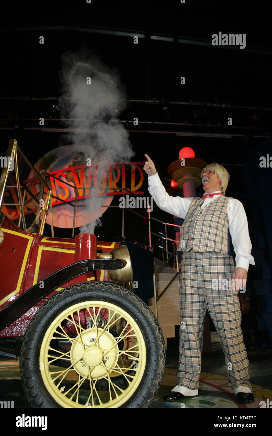 Zirkus Clown handeln mit kaputten Auto, Dampf und Rauch aus dem Motor. Stockfoto