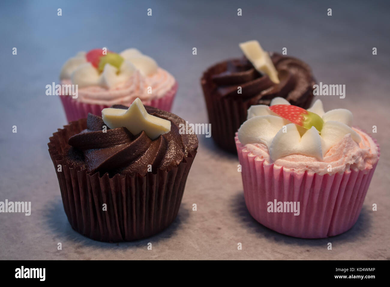 Erdbeer und Schokolade cupcakes durch heiße Schokolade mit Sahne und Schokolade abstauben begleitet. Stockfoto