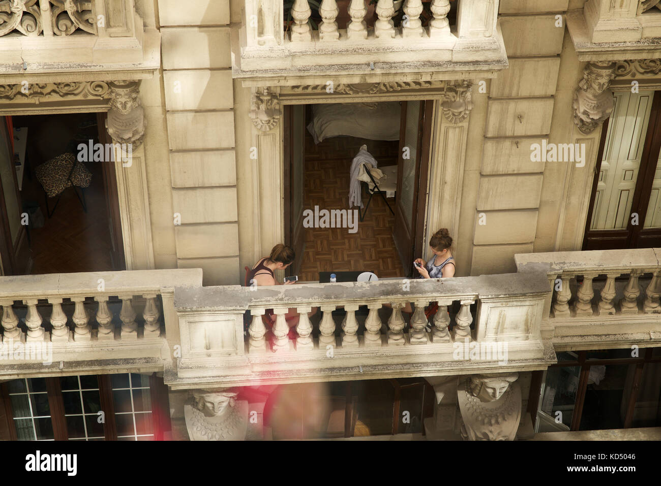 Zwei Mädchen auf ihre Mobiltelefone auf einem Balkon in Madrid Stockfoto