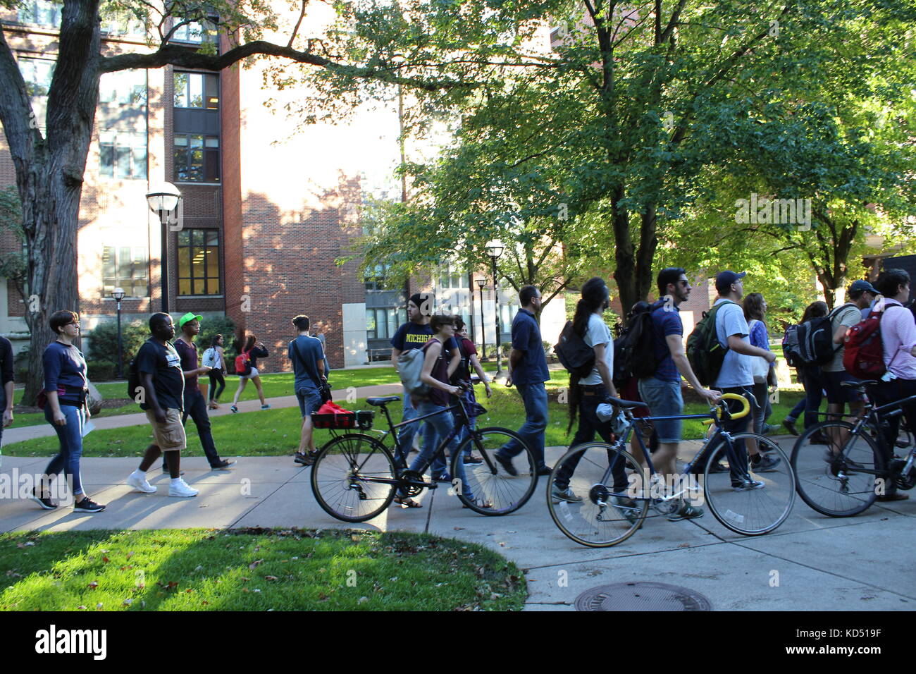 Am Ann Arbor Campus der University of Michigan im Zentrum von Ann Arbor, Michigan, spazieren zahlreiche Demonstranten mit dem Fahrrad die Straße hinunter Stockfoto