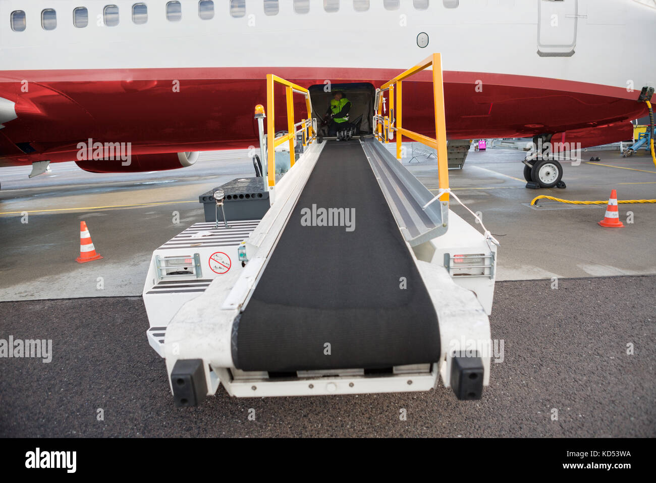 Gepäck Fördertechnik Lkw zu kommerziellen Flugzeug auf der Landebahn befestigt Stockfoto