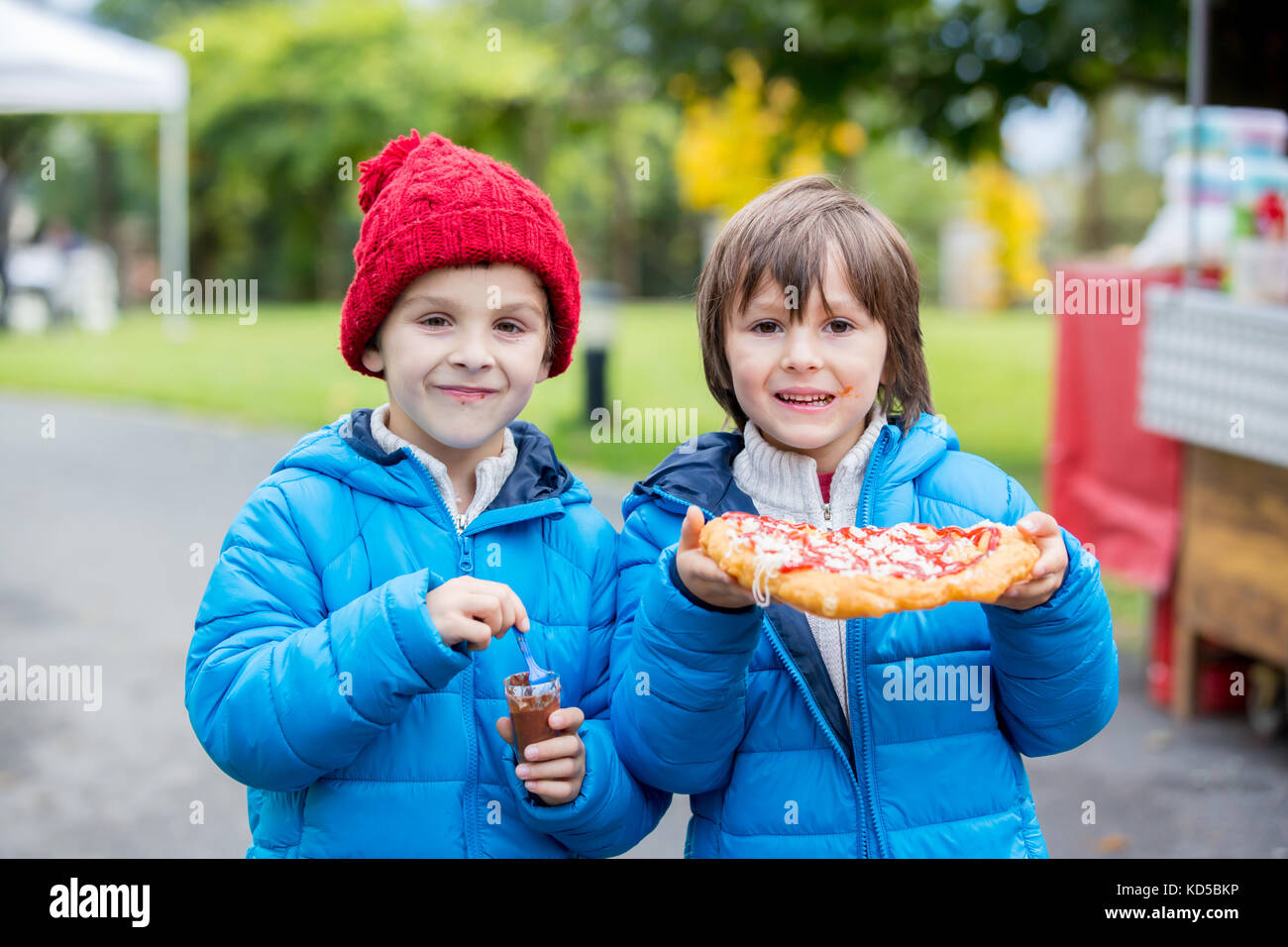 Junge Kinder im Vorschulalter, junge Brüder, salzig essen Brot mit Käse und Ketchup im Park, zusammen beißen Stockfoto