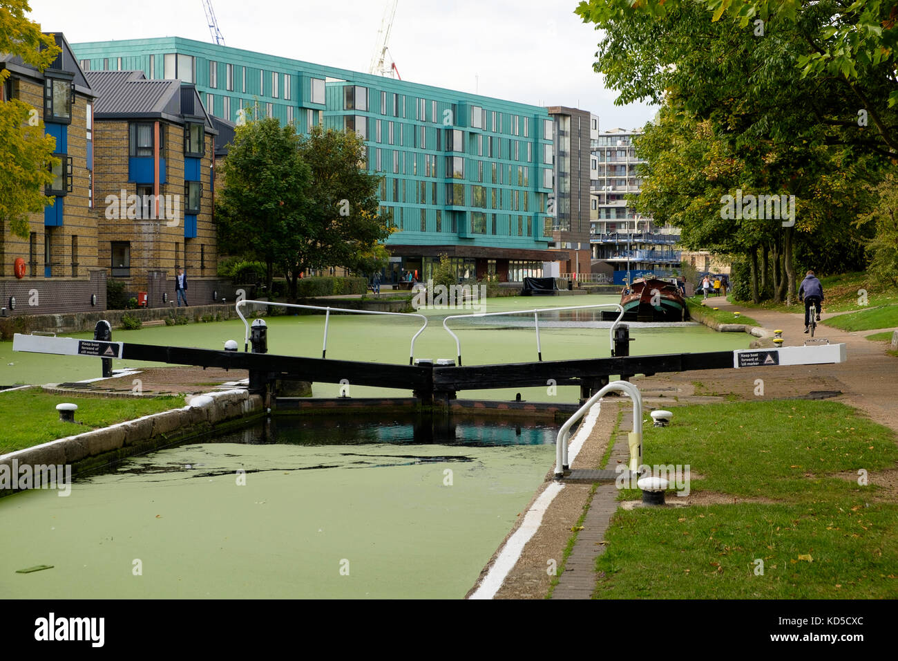 Am Mile End Lock am Regents Canal, London mit Gebäuden des Queen Mary College Campus Stockfoto