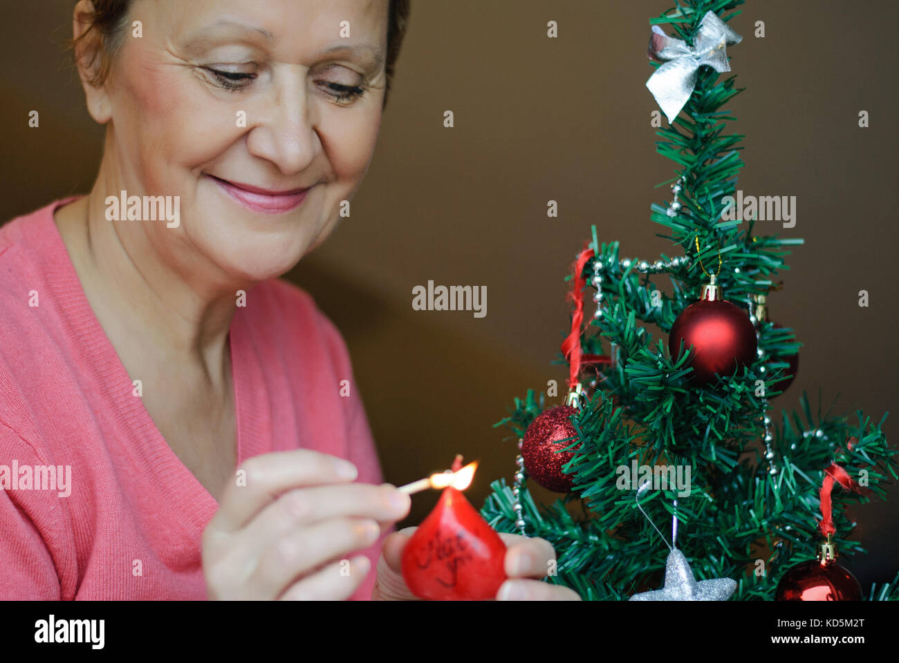 Schöne blonde Frau schmücken einen Weihnachtsbaum. Stockfoto