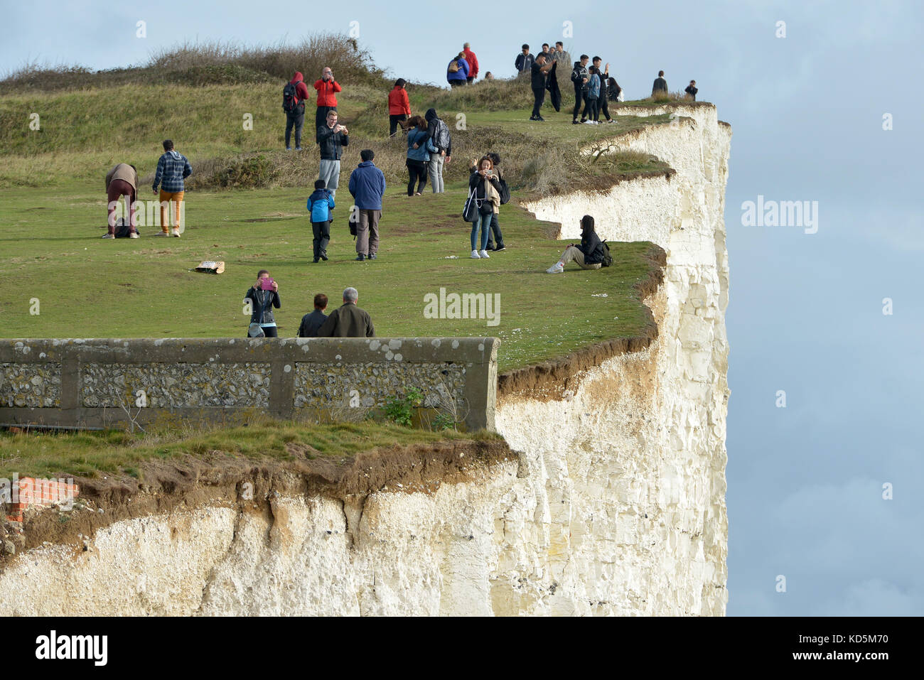 Touristen in der Nähe der Kante der Bröckelnden Kreidefelsen am Birlng Lücke, East Sussex Stockfoto