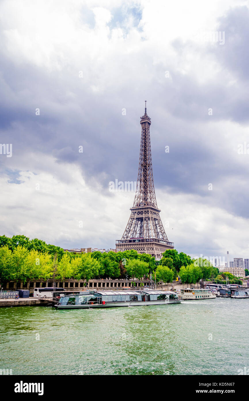 Den Eiffelturm von der rechten Bank mit der Seine im Vordergrund gesehen an einem bewölkten Tag Paris. Stockfoto