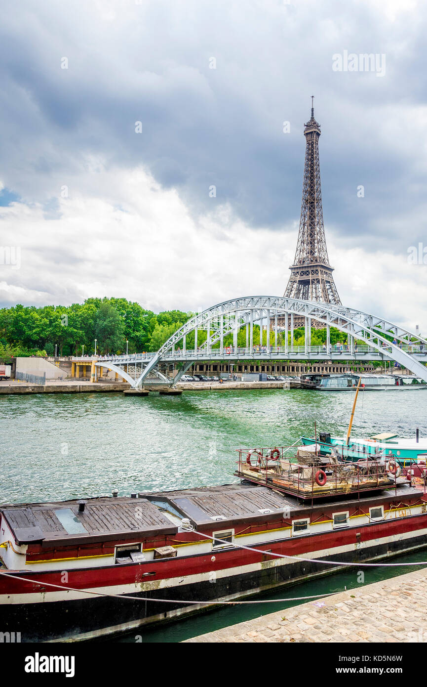 Den Eiffelturm von der rechten Bank mit der Seine im Vordergrund gesehen an einem bewölkten Tag Paris. Stockfoto