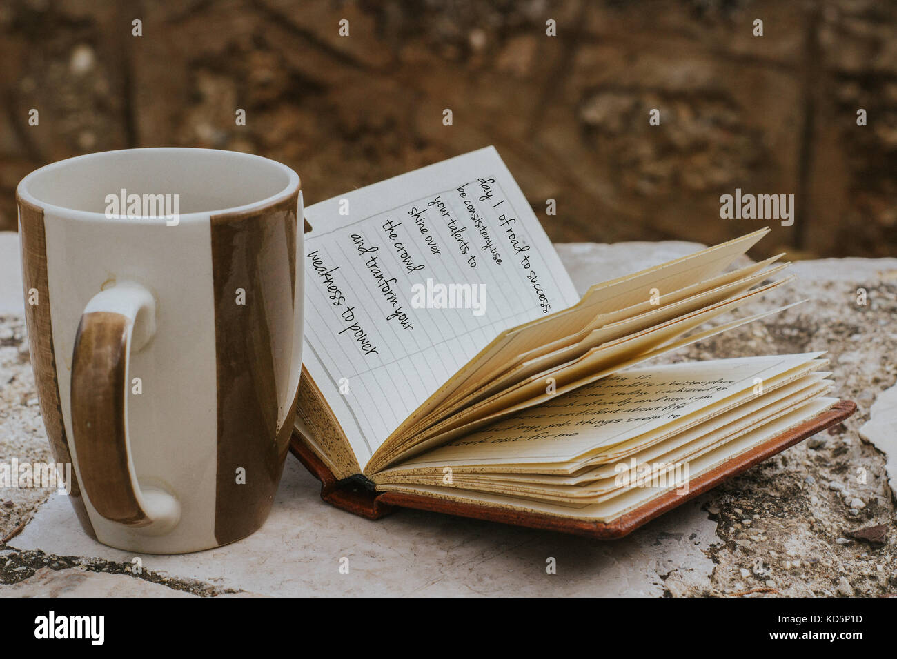 Kaffeebecher und eine kleine offene Notebook über Straße Schreiben zum Erfolg Stockfoto