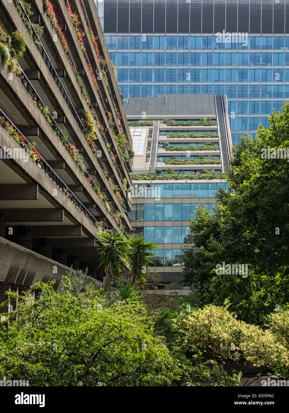 LONDON, Großbritannien - 25. AUGUST 2017: Balkone der Wohnungen im Barbican Estate mit einem Bürogebäude im Hintergrund. Stockfoto
