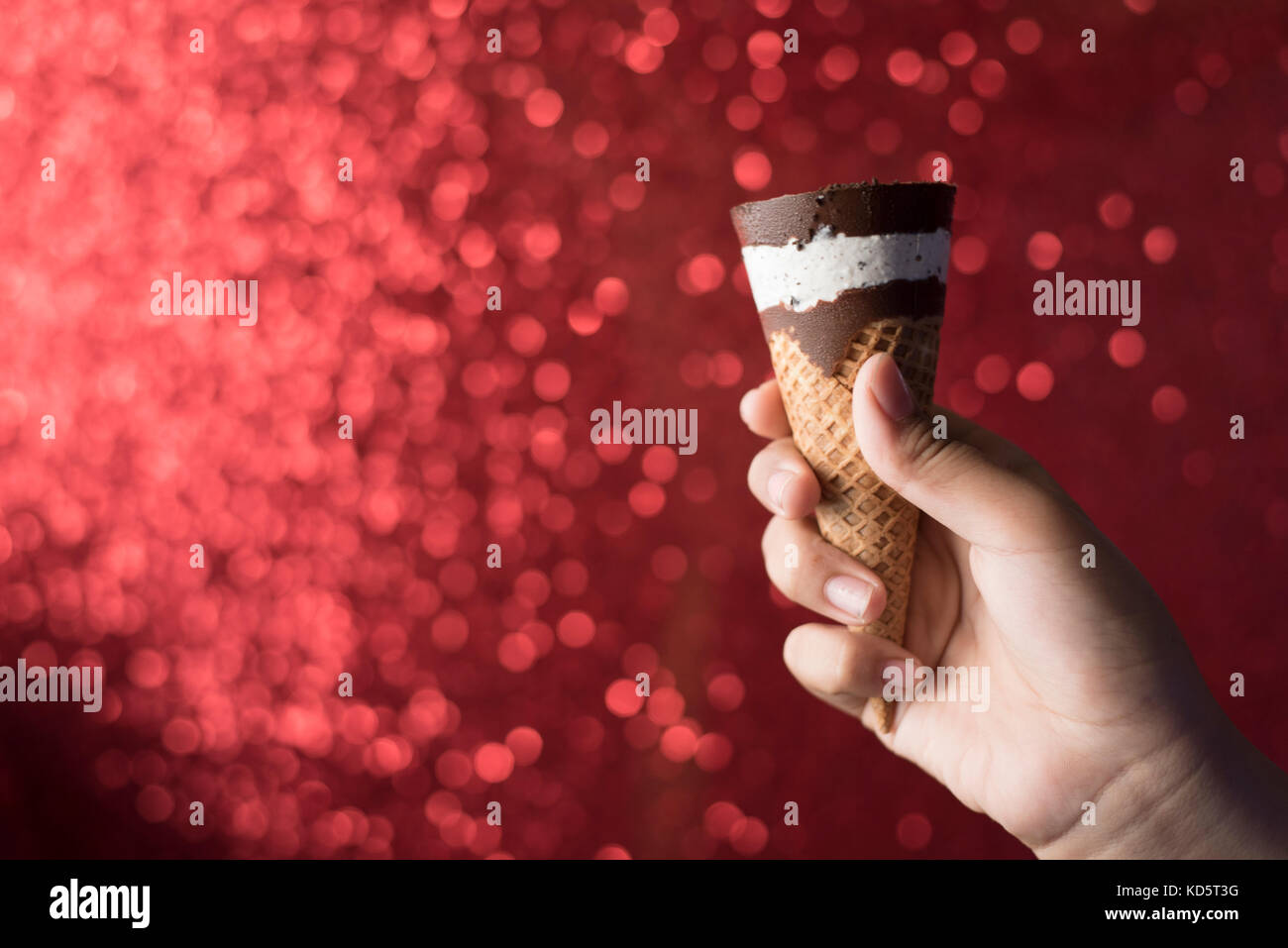 Hand/anzeigen Schokolade und Vanille Eis mit glänzenden roten Hintergrund Stockfoto