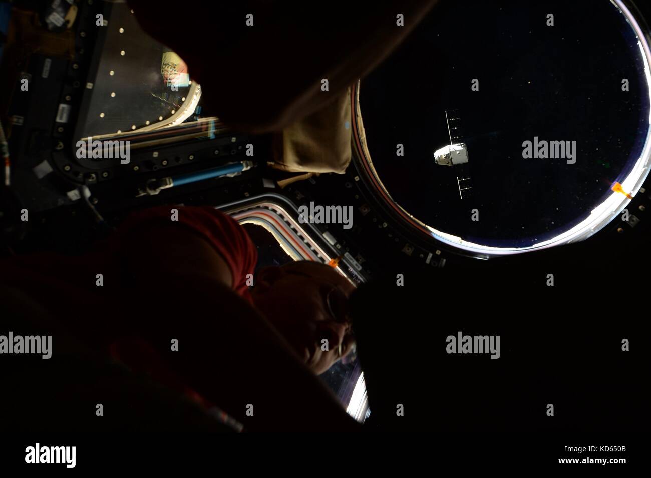 Die spacex Dragon capsule ist ein Fenster innerhalb der Internationalen Raumstation gesehen, wie es zurück auf die Erde 17. September fährt, 2017 in der Erdumlaufbahn. Stockfoto