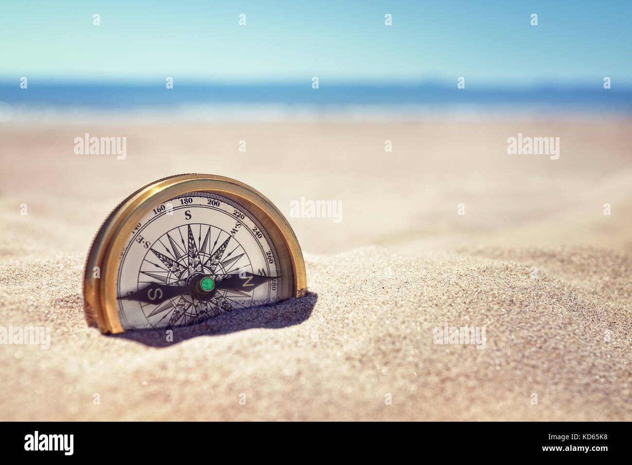 Goldene Kompass in den Sand am Strand Konzept für verlorene oder Richtung begraben Stockfoto