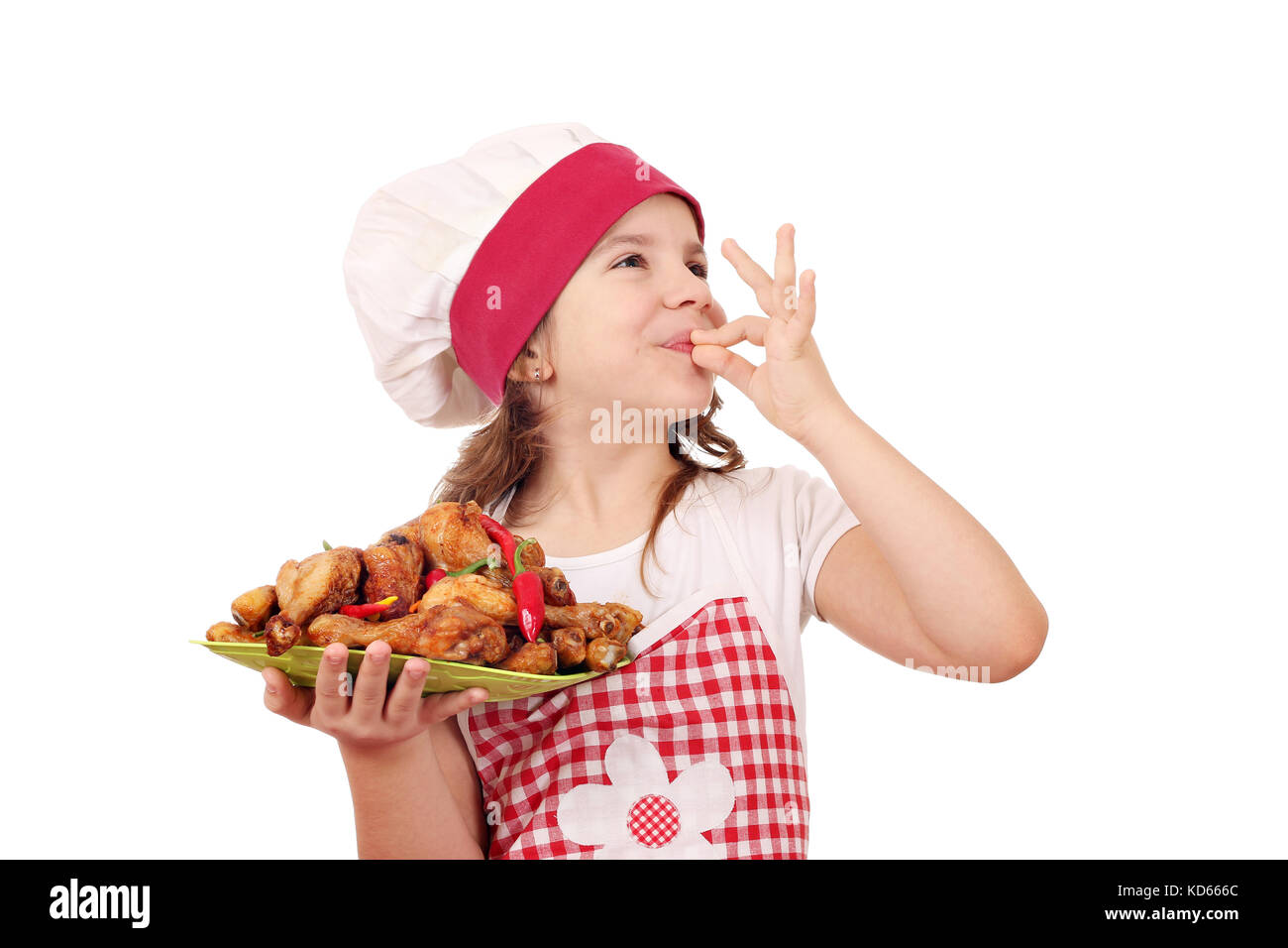 Gerne kleine Mädchen Kochen mit Huhn drumstick und ok Handzeichen Stockfoto