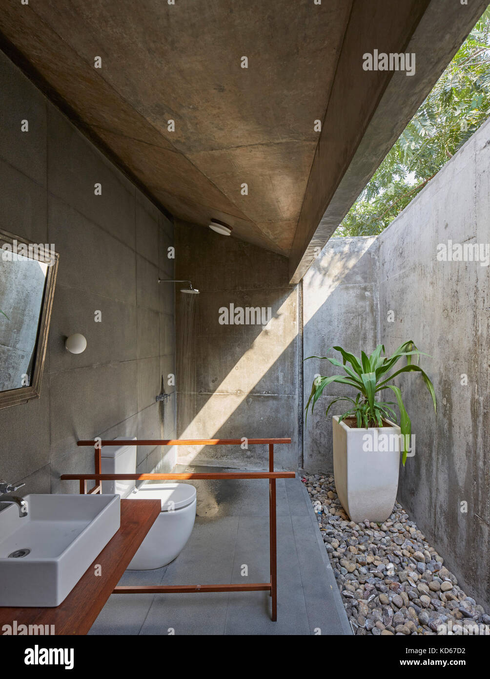 Raw Badezimmer mit Nachmittagssonne. Haus auf einen Stream, Alibaug, Indien. Architekt: Architektur BRIO, 2014. Stockfoto