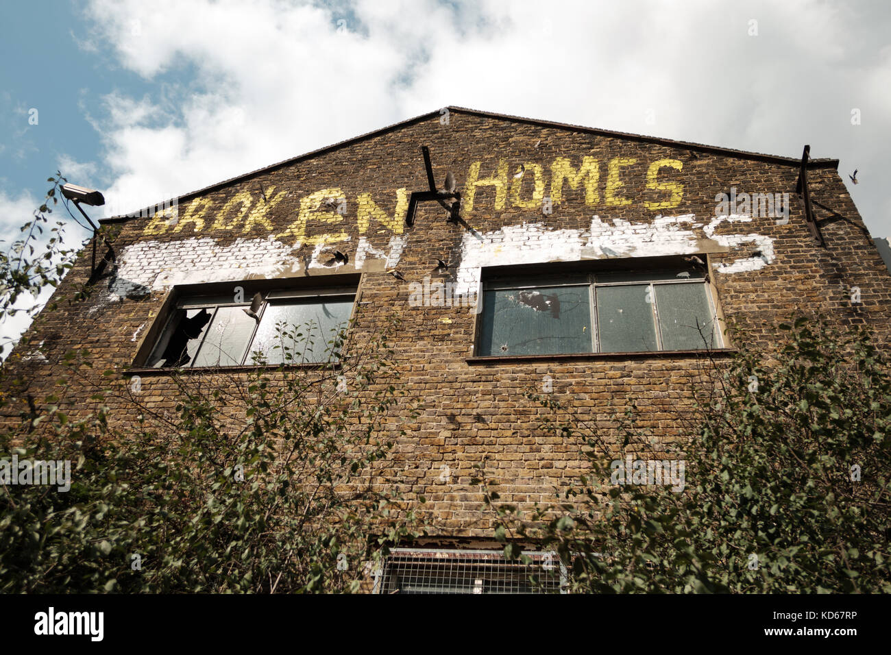 Verfallenes Gebäude mit Protest graffiti in East London, UK Stockfoto