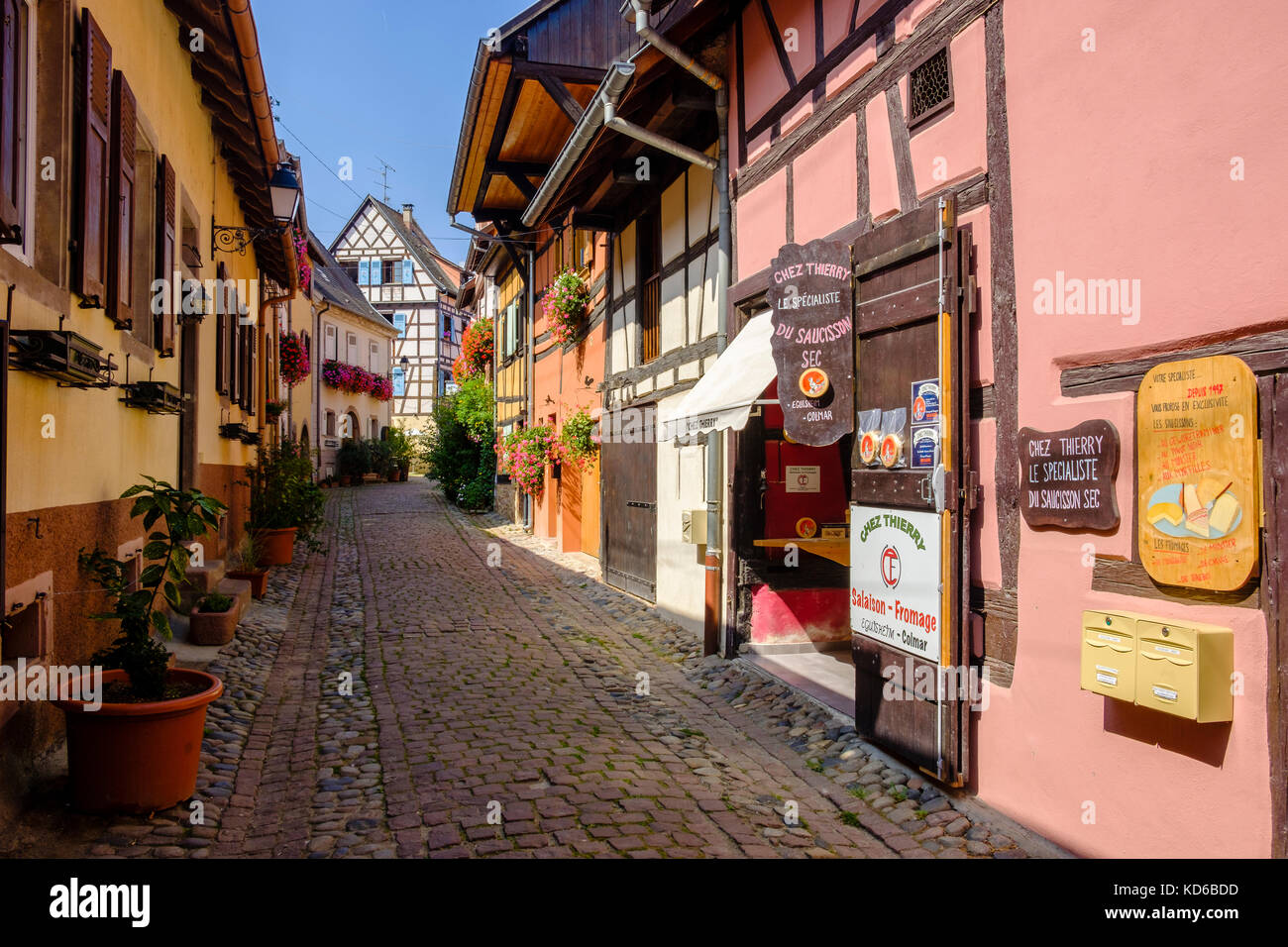 Eine kleine Straße führt durch die Blume dekoriert Fachwerkhäuser der historischen Dorf Stockfoto