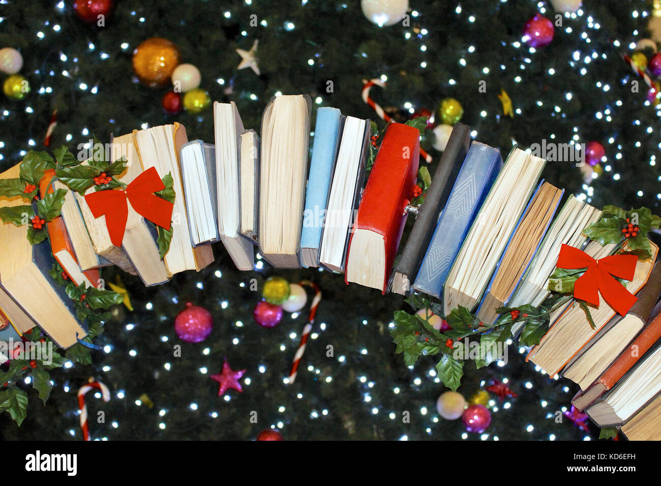 Bücher Ornamente mit rote Schleifen hängen von Weihnachtsbaum Stockfoto