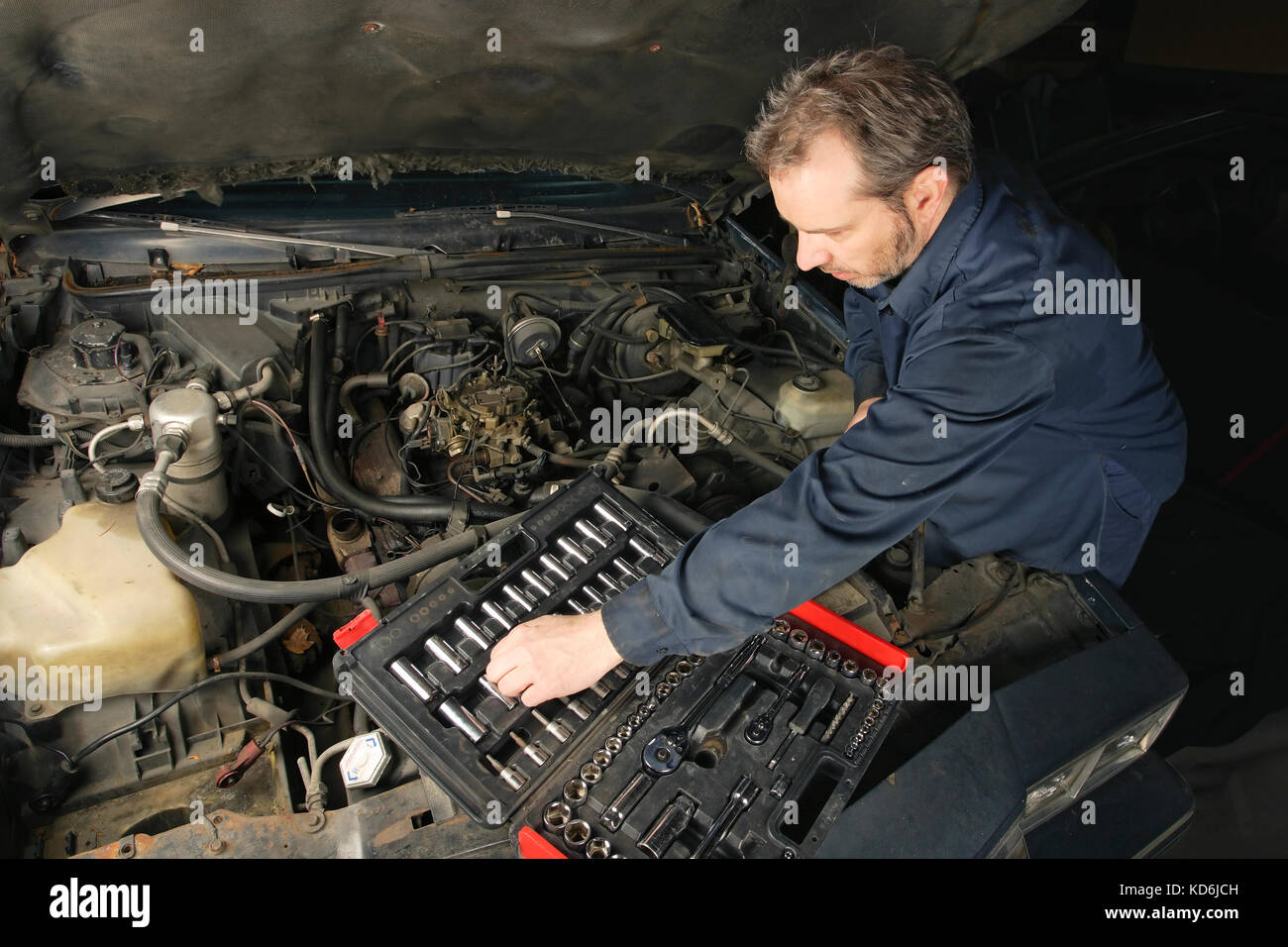 Foto von einem Mechaniker reparieren ein Motor für ein altes Auto. Stockfoto