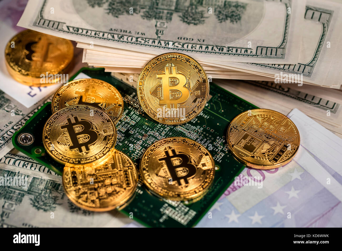 Detailansicht von Goldmünzen von bitcoin auf hundert Dollar Scheine. Stockfoto