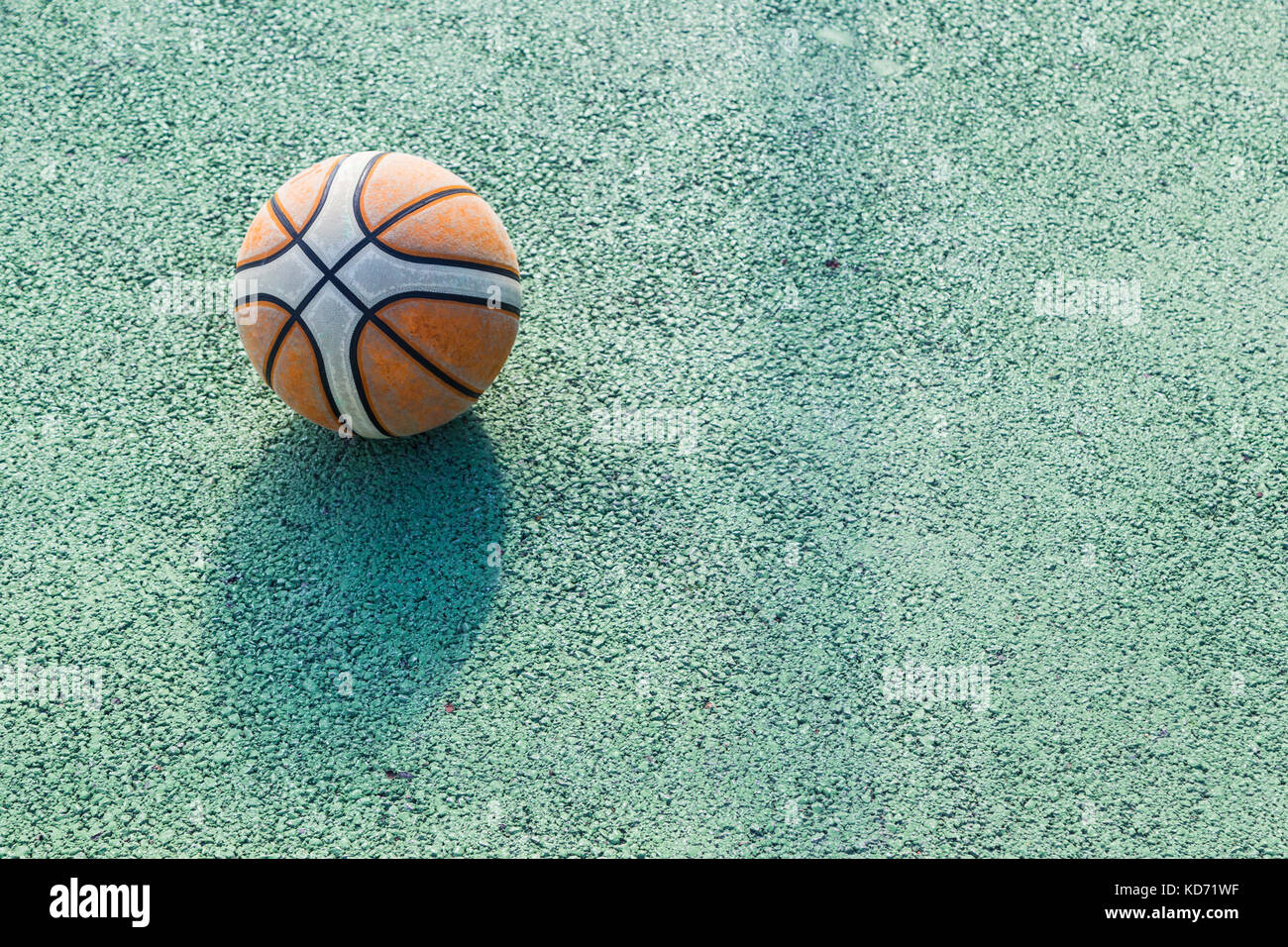 Alte Basketball wird auf einem grünen Baskettballplatz draußen an einem sonnigen Tag links, Raum für Text oder Kopie Raum Stockfoto