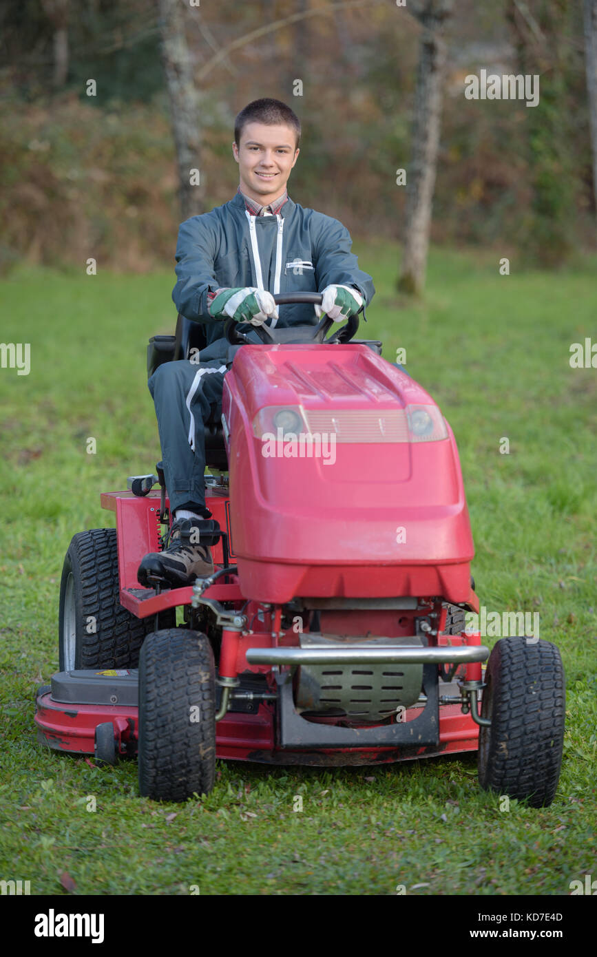 Junge Gärtner auf einem rasentraktor Stockfoto