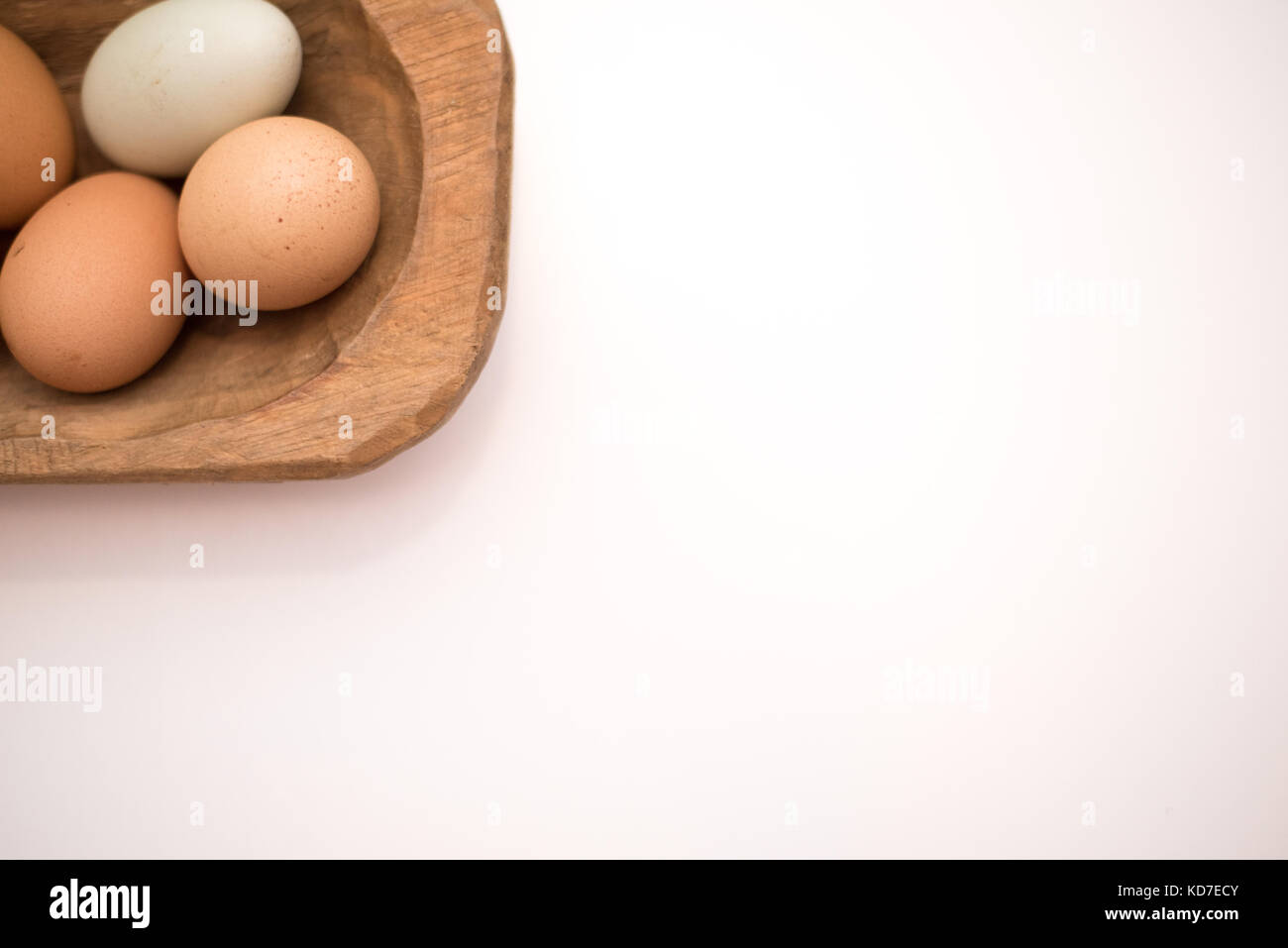 Organische frische Eier vom Bauernhof in einem Vintage Brown Bread bowl auf einem weißen Hintergrund. Großartig für Hintergründe und Werbung. Stockfoto