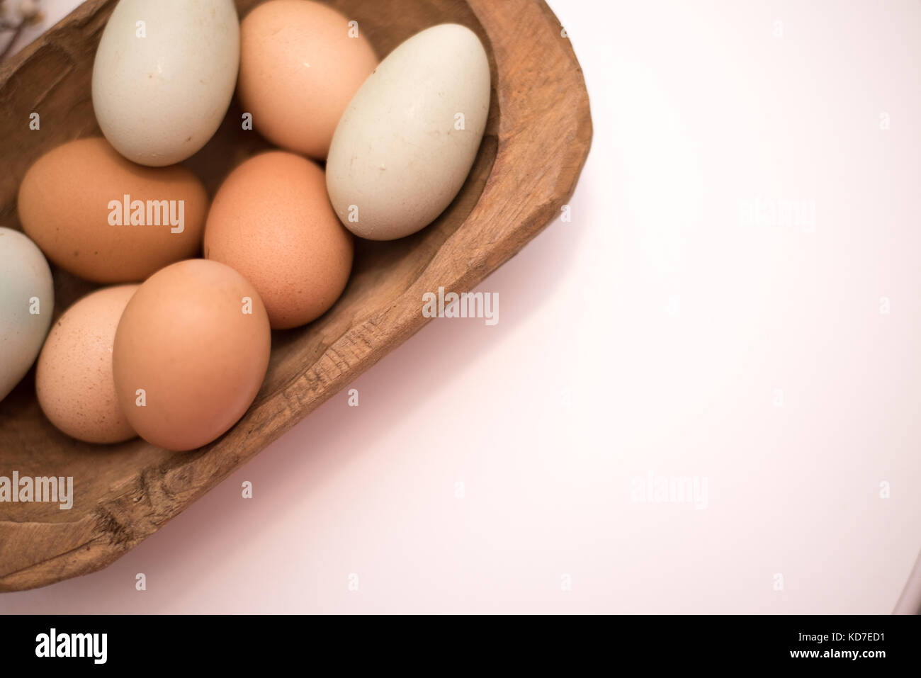 Organische frische Eier vom Bauernhof in einem Vintage Brown Bread bowl auf einem weißen Hintergrund. Großartig für Hintergründe und Werbung. Stockfoto