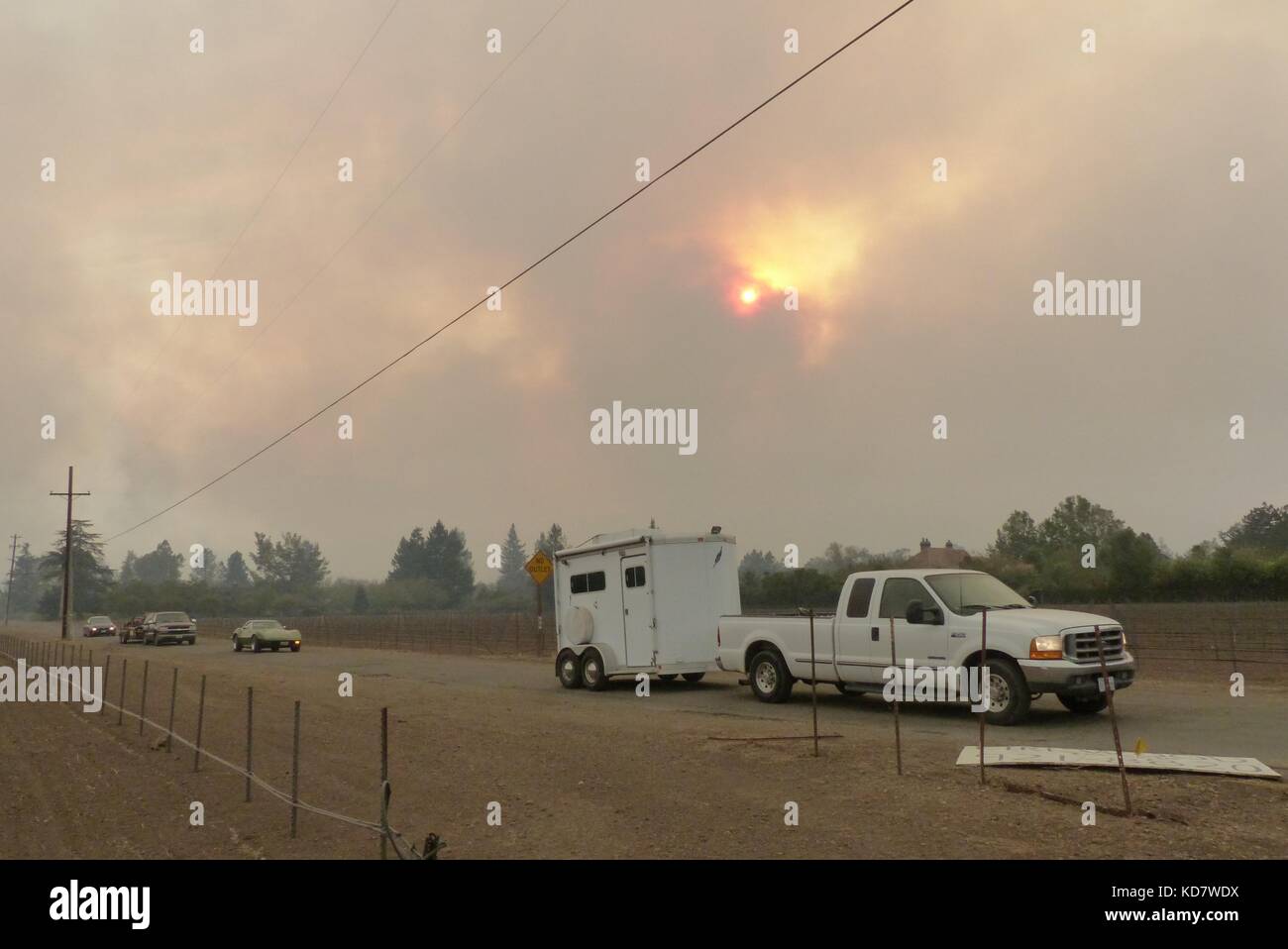 Santa Rosa, USA. Oktober 2017. Die Bewohner flüchten vor Flammen in ihren Autos in Santa Rosa, USA, 10. Oktober 2017. Autos wurden zu schwelendem Schrott reduziert, Gebäude verbrannt. Viele Kalifornier, die vor dem Ansturm der Flammen geflohen sind, kehren nun in einen Albtraum zurück. Die Gefahr hat 17 Menschen ihr Leben verursacht, darunter ein Paar im Alter von 100 und 98 Jahren, so die vorläufigen Statistiken. Quelle: Barbara Munker/dpa/Alamy Live News Stockfoto