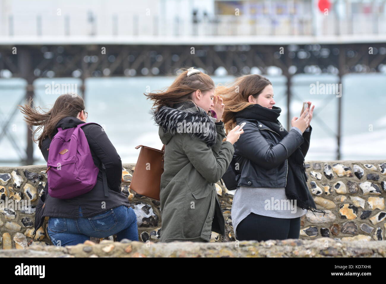 Studentinnen, die in den Wind am Meer im Herbst, im Vereinigten Königreich. Stockfoto