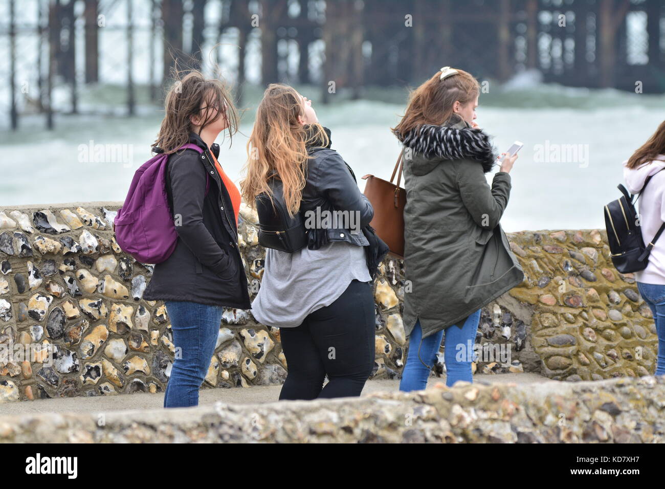 Studentinnen, die in den Wind am Meer im Herbst, im Vereinigten Königreich. Stockfoto