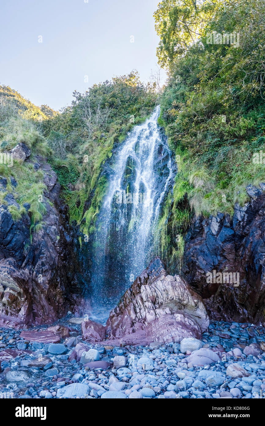 Wasserfall auf dem Strand in Clovelly, eine kleine Heritage Village in North Devon, eine touristische Attraktion ist berühmt für seine steilen gepflasterten Main streetand Meerblick Stockfoto