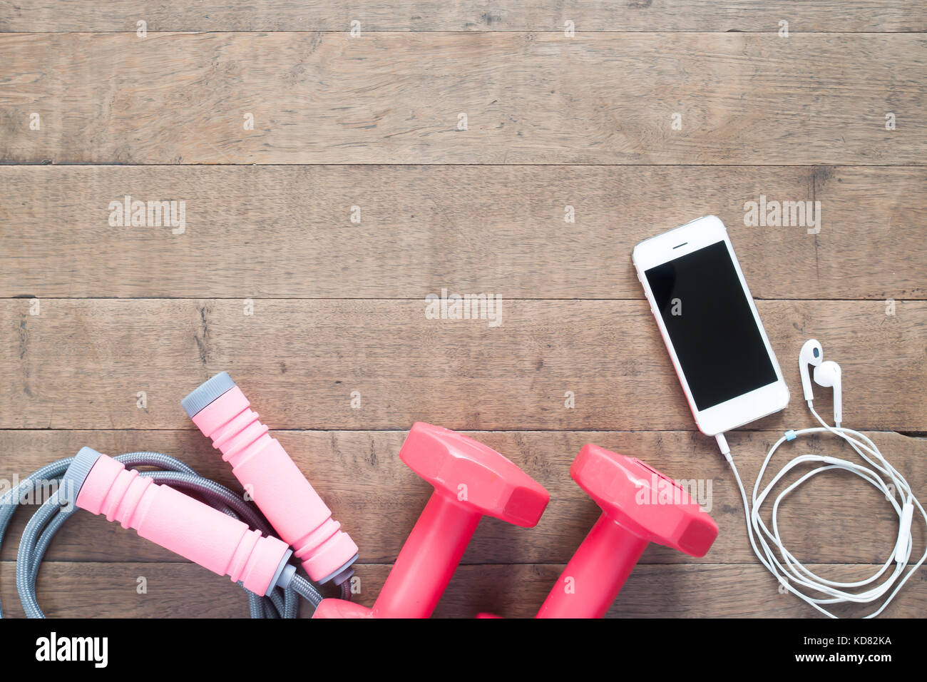 Sport- und Fitnessgeräte mit Mobil- und Ohrhörer auf Holz Hintergrund Stockfoto