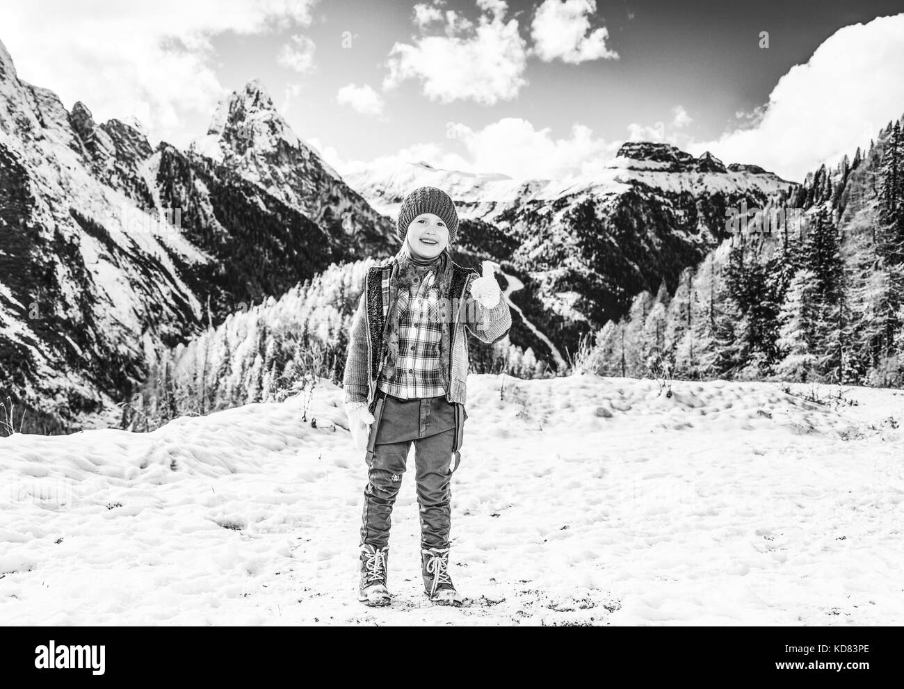 Winter auf höherer Ebene spaß. in voller Länge Porträt der lächelnden Mädchen gegen Bergwelt in Südtirol, Italien mit Daumen hoch Stockfoto