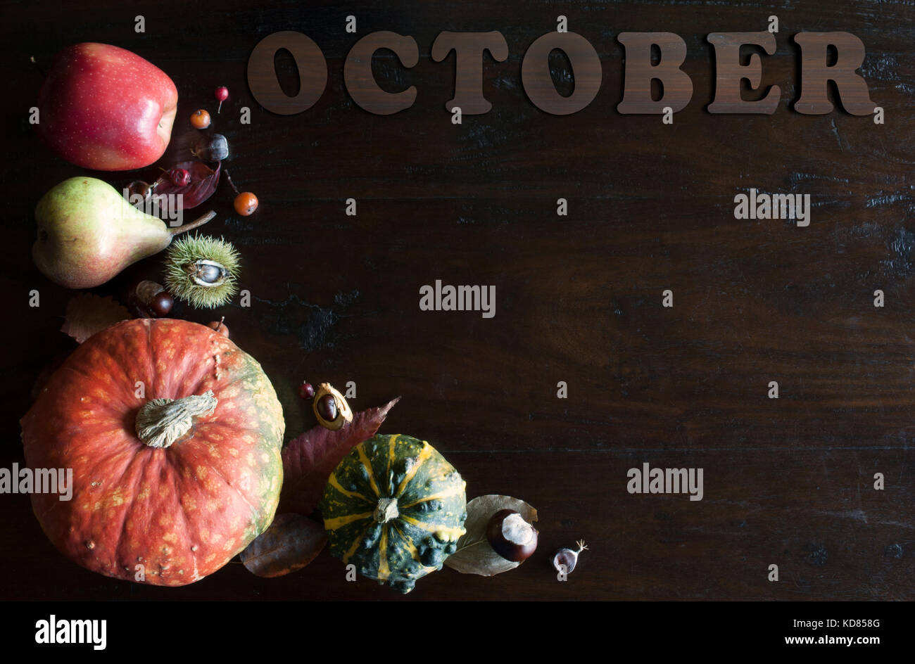Schöne rustikale fallen flach mit Blättern, Kürbis, Kastanien und Buchstaben Oktober auf hölzernen Hintergrund Stockfoto