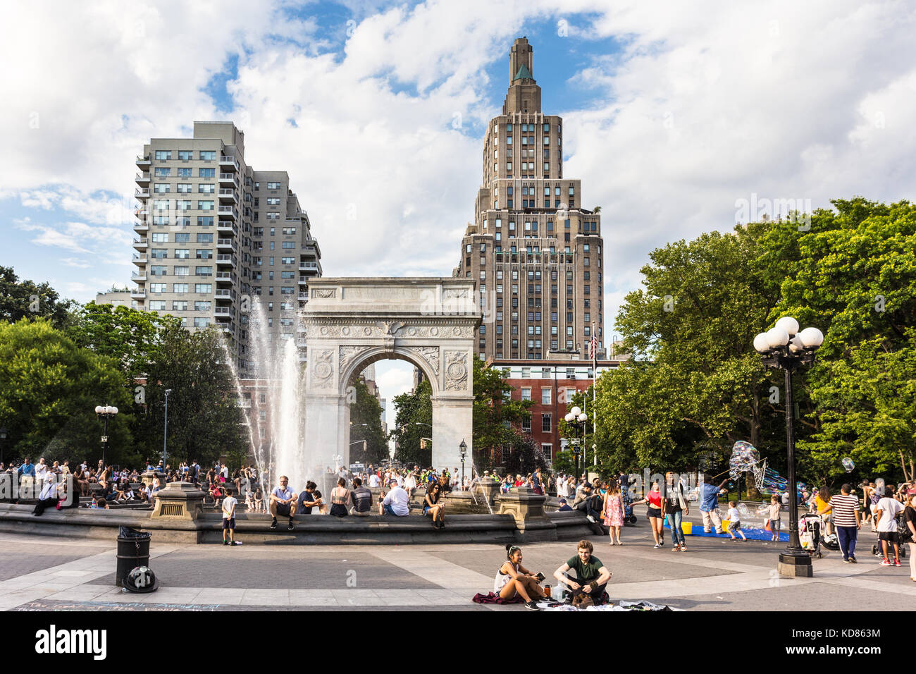 NEW YORK CITY - 3. JULI 2017: An einem sonnigen Sommersonntag im Washington Square Park im Herzen von Manhattan genießen die Menschen Straßenauftritte Stockfoto