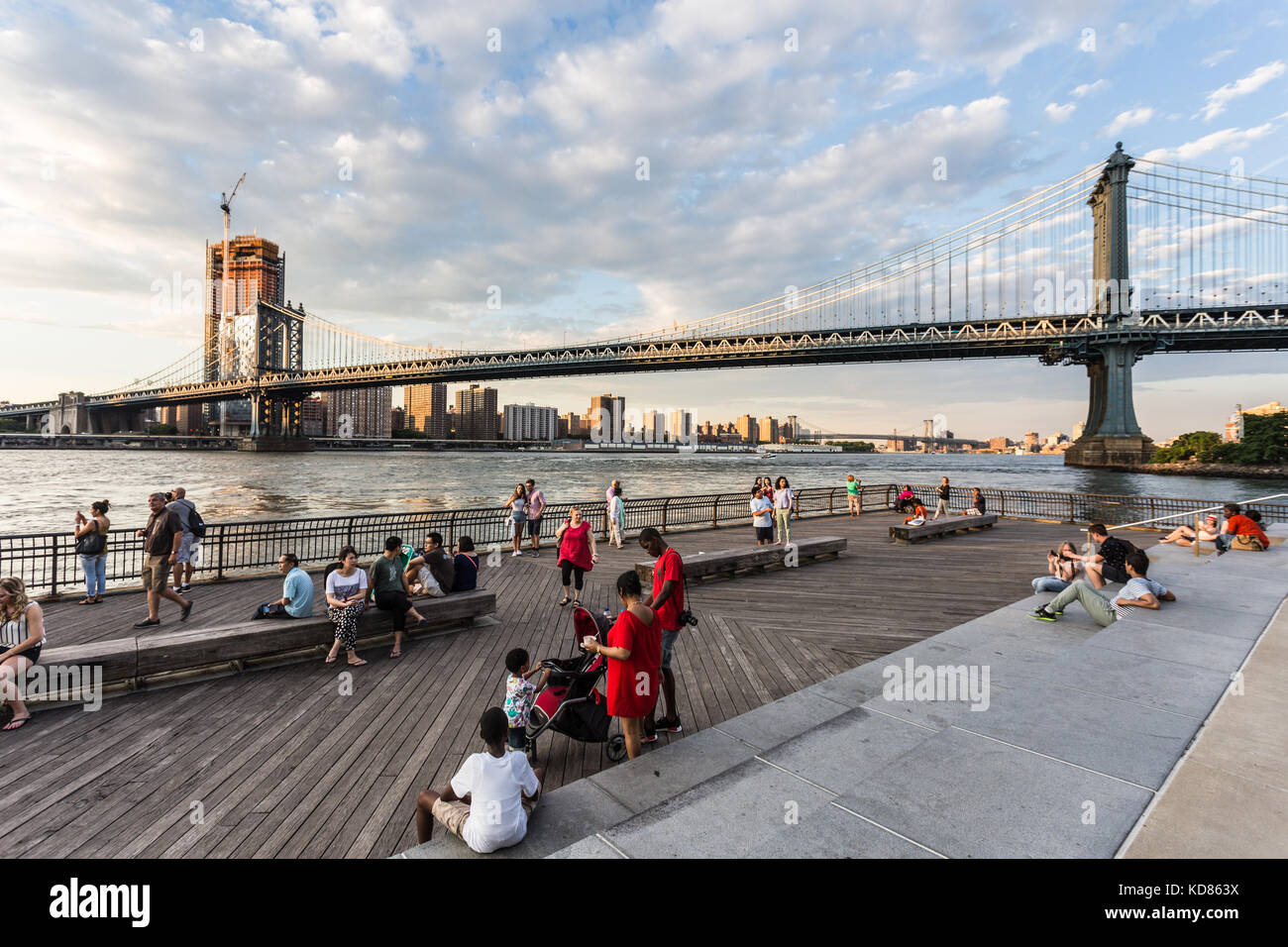 New York City - 3. Juli 2017: Menschen den Sonnenuntergang über die Manhattan Bridge und dem East River von der Brooklyn Bridge Park in New York City genießen. Stockfoto