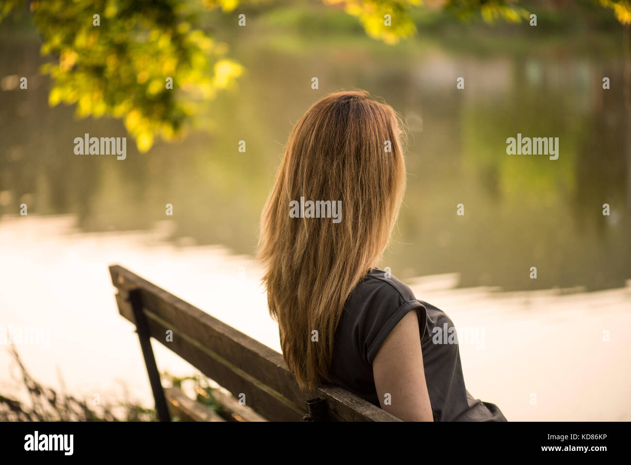 Frau sitzen auf einer Bank an einem See, Stara Zagora, Bulgarien Stockfoto