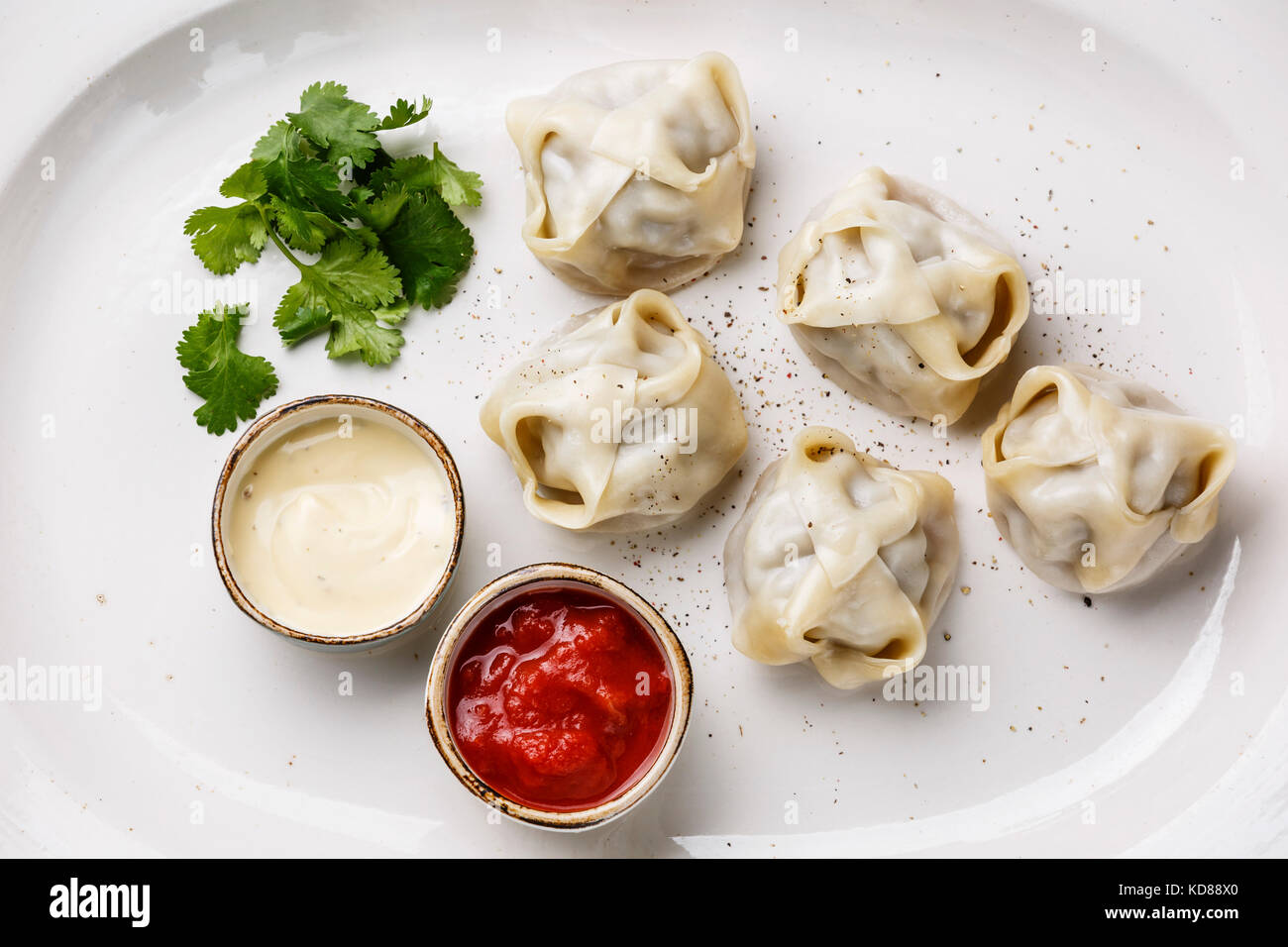 Traditionelle gedämpfte Teigtaschen manti mit Joghurt und Tomatensauce ...