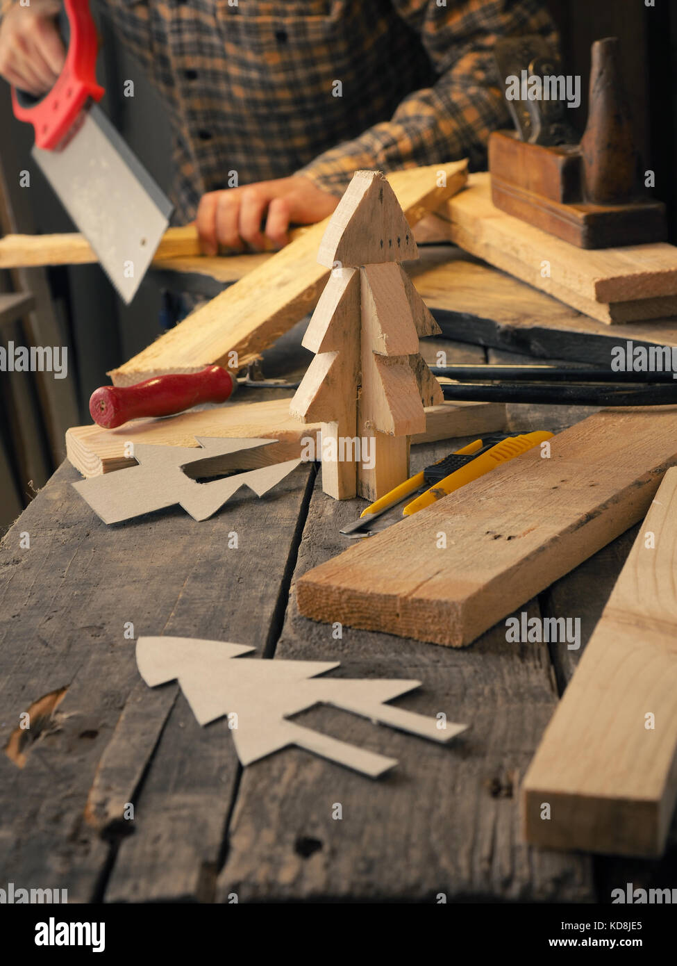 Heimwerker oder Schreiner arbeiten auf Holz, so dass ein Weihnachtsbaum, Kreativität oder Ideen Konzept Stockfoto