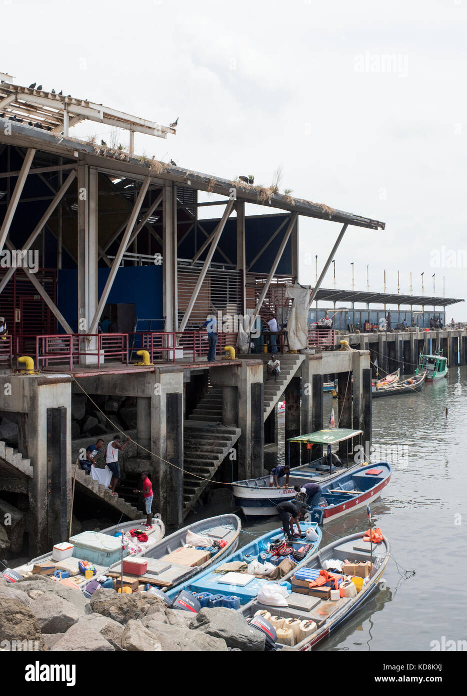 Docks Arbeitnehmer aufder Kai waren an Land bringen mit kleinen Booten in Panama City durch Vögel warten Fische zu stehlen beobachtet. Stockfoto