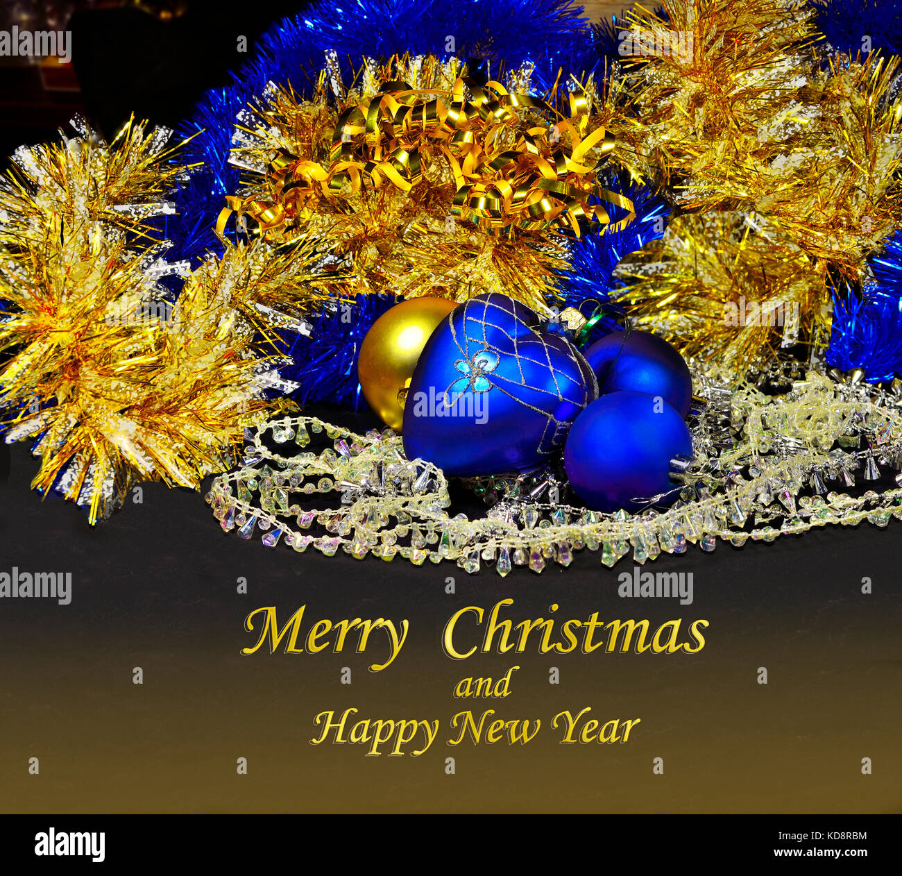 Weihnachten festliche Postkarte mit blauen und goldenen Kugeln und Lametta auf einem dunklen Hintergrund und golden Text frohe Weihnachten und ein glückliches neues Jahr Stockfoto