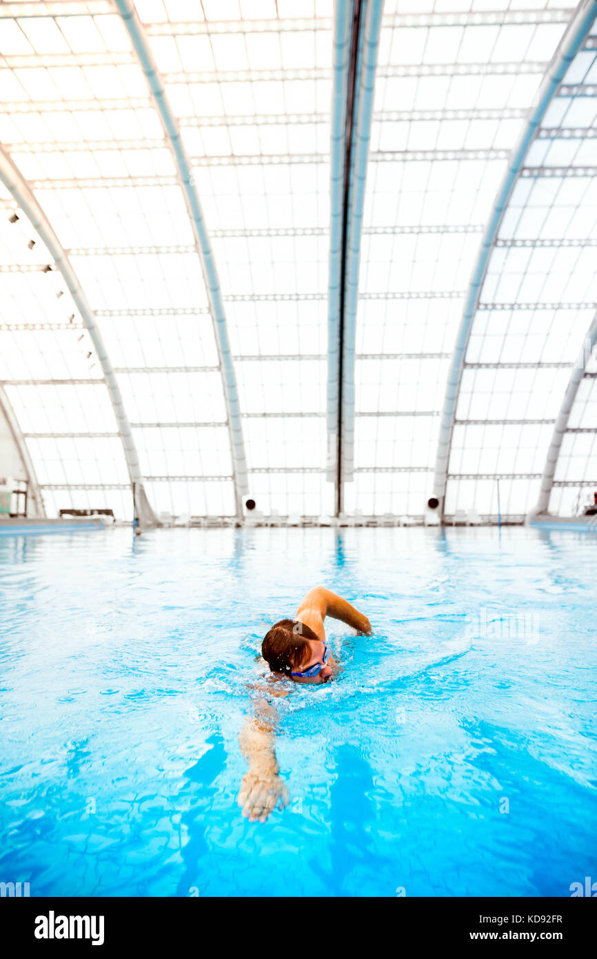 Mann Schwimmen im Innenpool. professionelle Schwimmer üben im Pool. Stockfoto