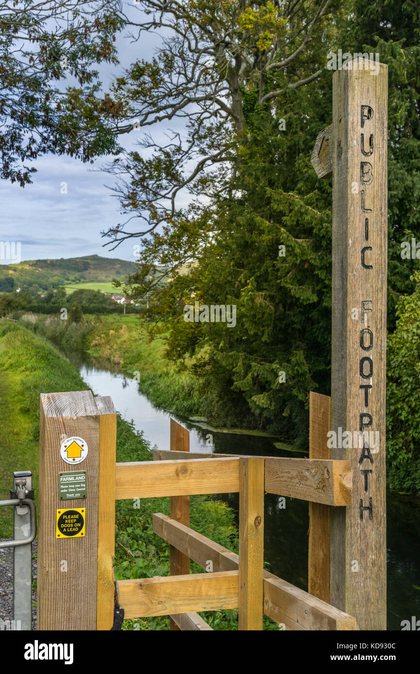 Ein öffentlicher Weg Zeichen zeigt den rechten Weg entlang eines kleinen Baches in Somerset, England. Stockfoto