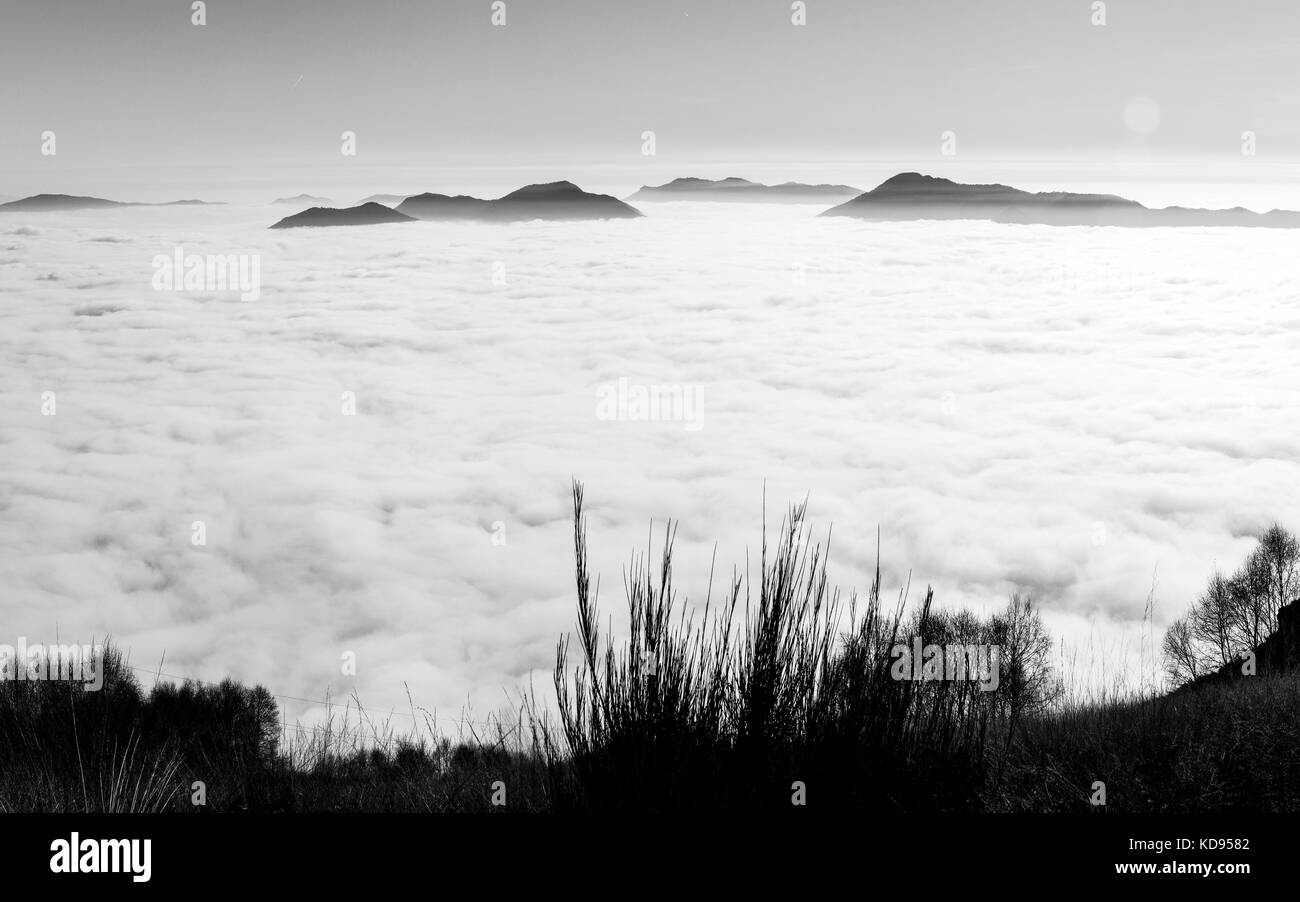 Ausdehnung des weißen Wolken zwischen den Alpen über den Lago Maggiore Stockfoto