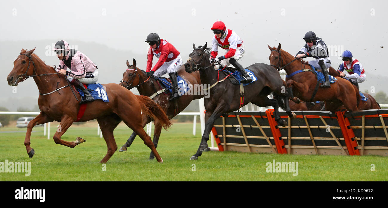 Läufer und Reiter überwinden eine Hürde in der Queen Elizabeth Humanities College Racing to School Juvenile Maiden Hürde auf der Ludlow Racecourse. Stockfoto