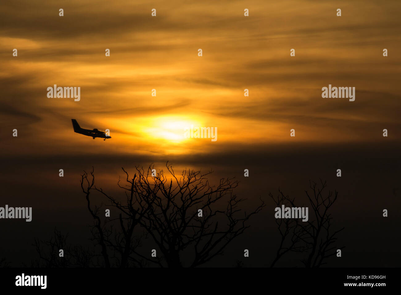 Kleines Flugzeug nähert sich Flughafen bei Sonnenaufgang Stockfoto