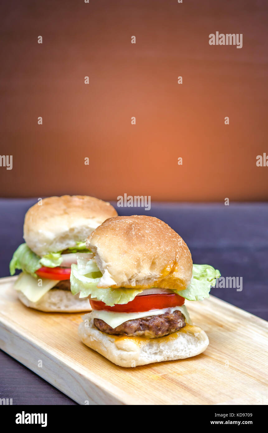 Leckere hausgemachte gourmet Käse Burger aus Rindfleisch mit frischen Zutaten auf Holz- Platten platziert Stockfoto