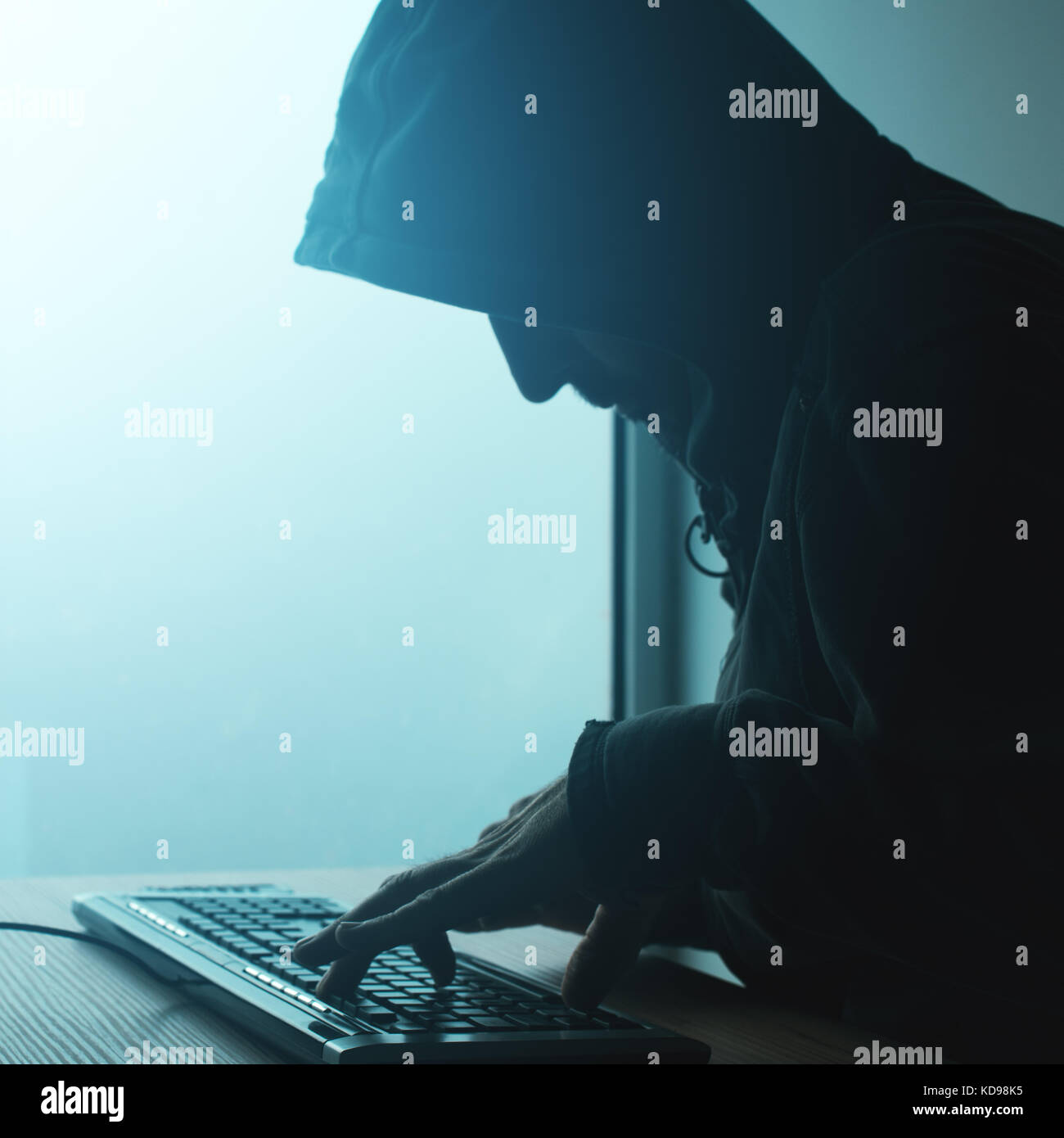 Hooded computer Hacker hacking Network. Männliche mit Schwarz mit Computer für Identitätsdiebstahl oder andere kriminelle Online-aktivitäten Hoodie. Stockfoto