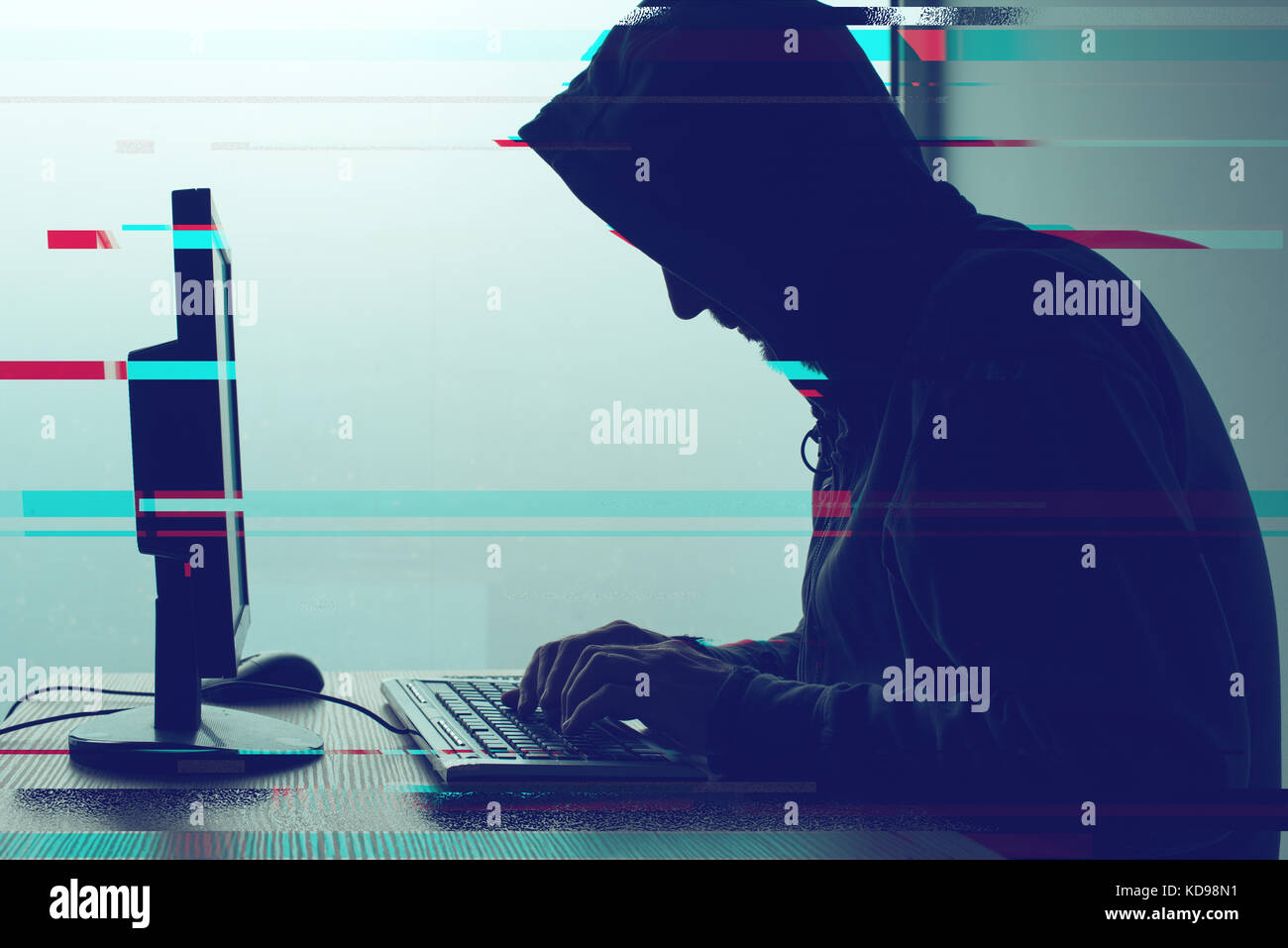 Hooded computer hacker Arbeiten am Desktop-PC Computer. p2p und Produkt- und Dienstleistungspiraterie, Computerviren und Trojaner, Phishing, Malware und ransomware Konzept mit glitc Stockfoto